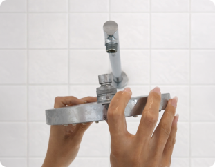 Hands unscrewing existing shower fixture
