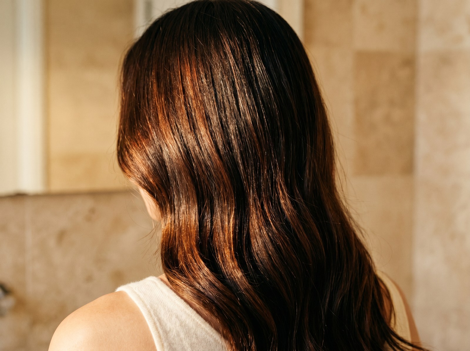Glossy warm-brunette hair holding its salon color